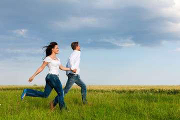 Happy couple running on a dirt road