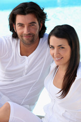 Couple wearing white next to a pool