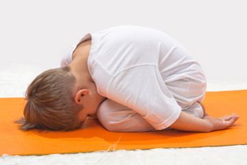 Children's yoga. The little boy does exercise.