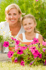 Gardening -  girl helping mother in the flowers garden