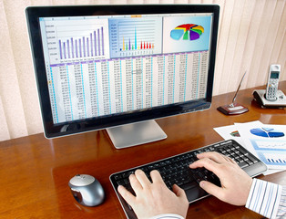 Male hands on the keyboard in front of computer screen