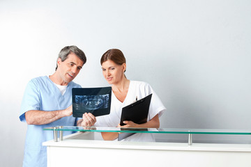 Zahnarzt und Zahnarzthelferin analysieren Röntgenbild