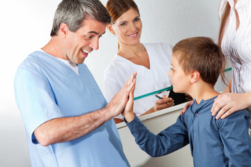 Arzt begrüßt Kind mit High Five