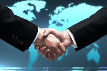 handshake of two business people on background of world map