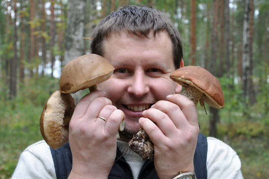 Man holds mushrooms in wood