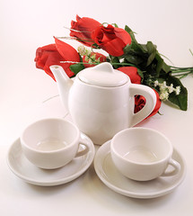 tazzine di caffè e rose su sfondo bianco