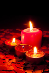 Four burning candles over red background