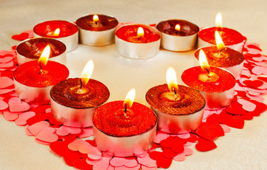 Many burning candles in a form of heart