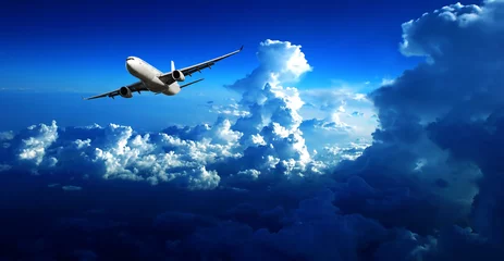 Foto op Canvas het vliegtuig dat door wolken vliegt © photofang