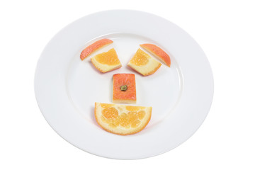 Fototapeta na wymiar Orange Pieces Arranged in Shape of Face on Plate