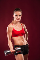 young fit woman lifting dumbell
