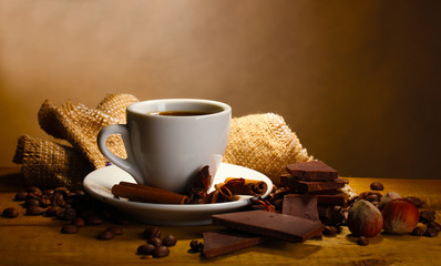 coffee cup and beans, cinnamon sticks, nuts and chocolate