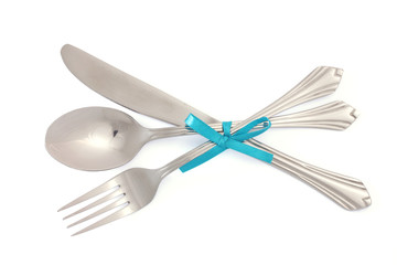 Silver fork and spoon, knife tied with a blue ribbon isolated