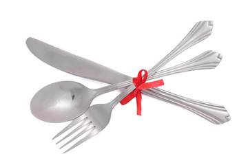 Silver fork and spoon, knife tied with a red ribbon isolated