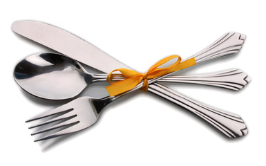 Silver fork and spoon, knife tied with a yellow ribbon isolated