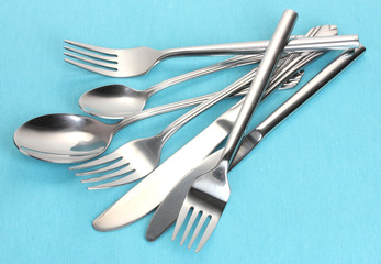 Forks, spoons and knives on a blue tablecloth