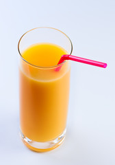 Orange juice with tubule in glass.