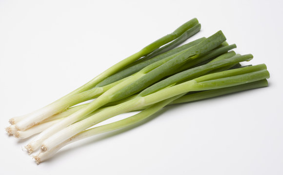 Green onions or scallions on white with tops trimmed