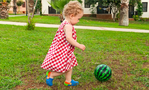 child playing with ball in garden