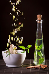 Fresh herbs falling down into the white mortar