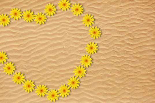 Heart made of flowers on sandy beach
