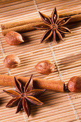 Closeup nuts and star anise on wooden bamboo mat