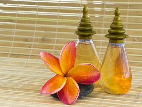 Spa concept - Plumeria and shampoo bottles on bamboo mat