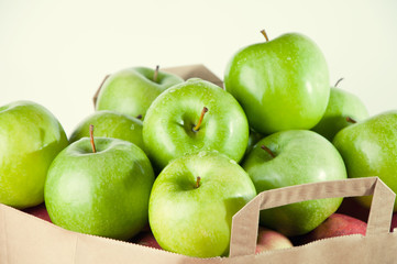 Close-up of a paper bag full of fresh green apples