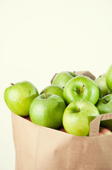 Grocery paper bag full of green apples, copy space