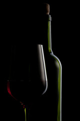 red wine in glass and bottle isolated on black