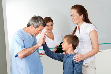 Kinderarzt begrüßt Jungen als Patient