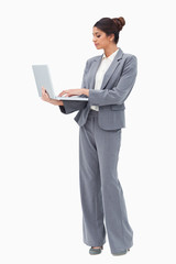 Businesswoman using laptop while standing