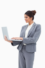 Smiling businesswoman using her laptop while standing