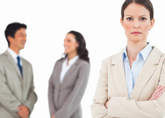 Serious tradeswoman with talking colleagues behind her