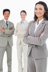 Smiling tradeswoman with folded arms and associates behind her