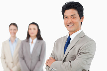 Confident smiling businessman with his team behind him
