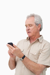 Mature man typing text message on his cellphone