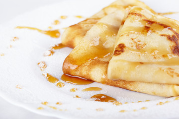 Thin pancakes with honey and powdered sugar