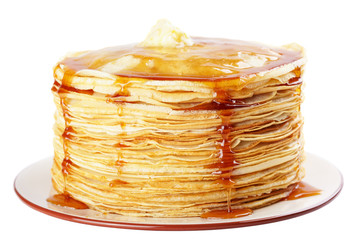 A stack of thin pancakes with honey and butter