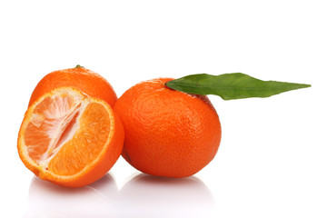 Ripe tasty tangerines with leaves and segments isolated on white