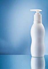 the single white bottle of cream on blue background