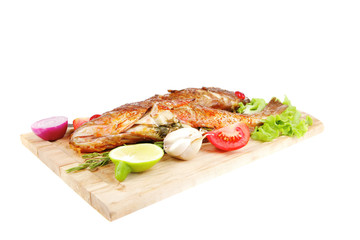 roasted sea fish on wood with tomatoes