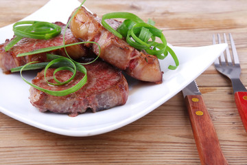 roasted beef meat on plate over wood