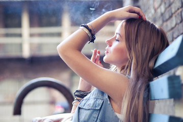 portrait smoking girl on the street in summer