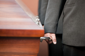 coffin bearer carrying casket at funeral