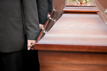 coffin bearer carrying casket at funeral - obrazy, fototapety, plakaty