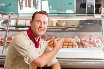 Butcher Pointing at Fresh Meat for Selling