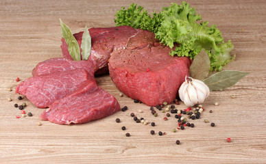 raw meat, vegetables and spices on gray background