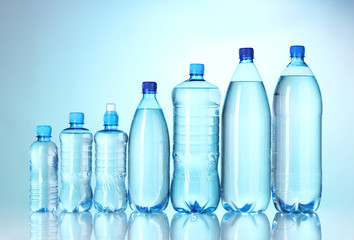 Naklejka premium Group plastic bottles of water on blue background