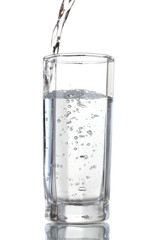 Pouring water on glass isolated on white